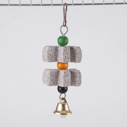 Two star-shaped pumice blocks separated by an orange bead, with green and black beads and a brass bell, clipped to cage wire. 6