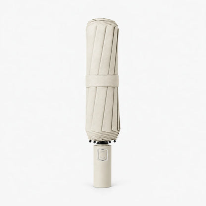 Folded cream umbrella standing handle-down on a white background, with a fabric strap around the pleated canopy. 10