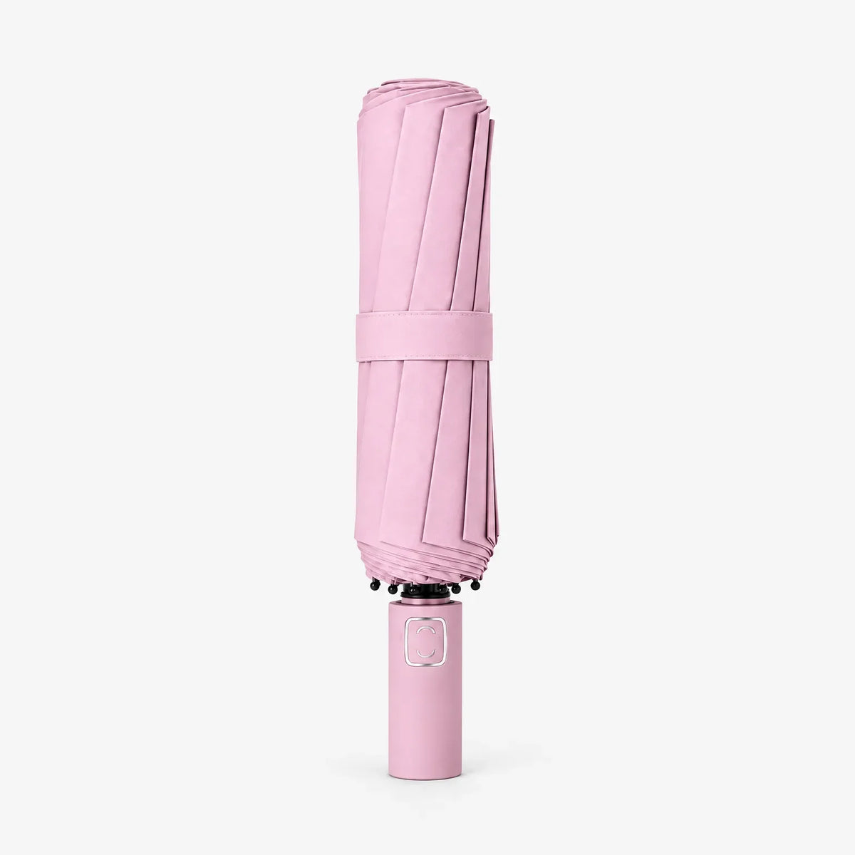 Folded pale pink umbrella standing handle-down on a white background, wrapped with a matching fabric strap around the canopy. 7