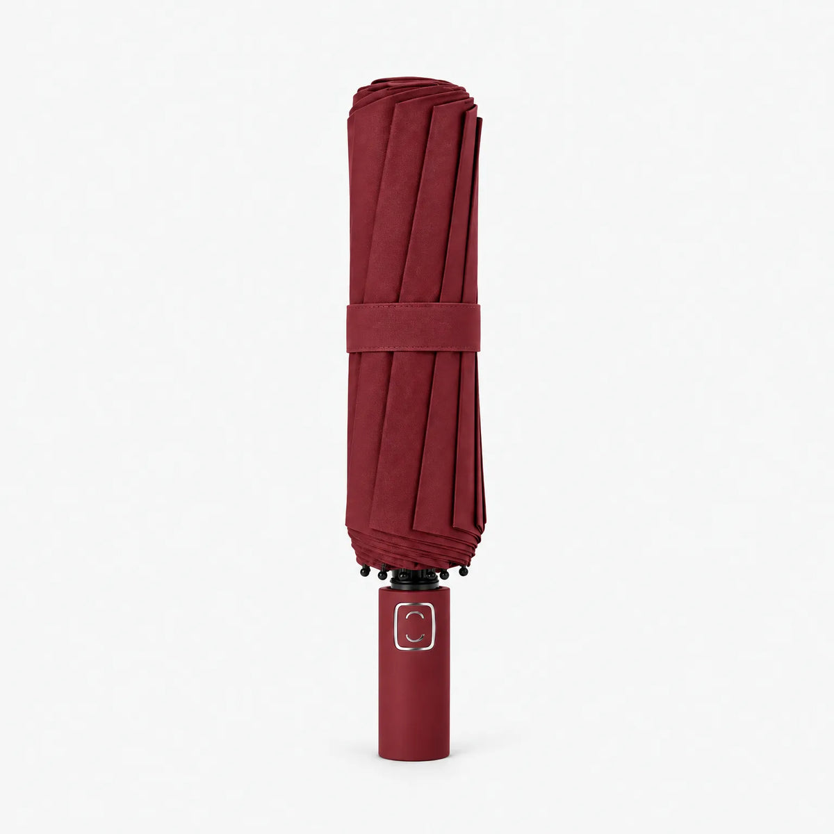 Folded burgundy umbrella standing handle-down on a white background, with a matching fabric strap and black rib tips at the top. 9