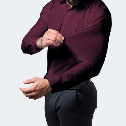 Burgundy shirt on a model, one hand stretching the sleeve fabric away from the arm 10