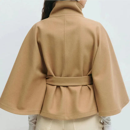 Back view of the camel cape jacket on a model, with the belt gathering the waist 2