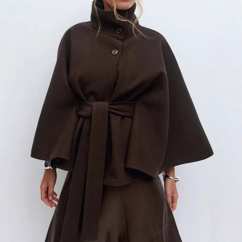 Dark brown cape jacket on a model, worn with a brown skirt and silver bracelets 4