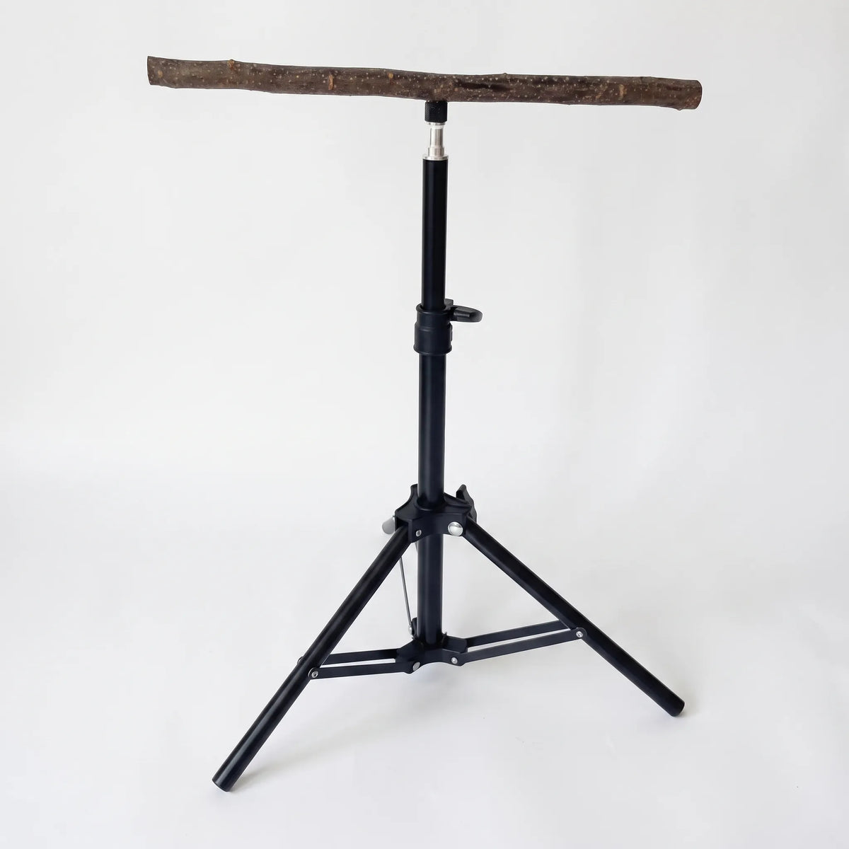 Black telescopic tripod stand topped with a natural wooden branch perch, shown empty against a plain white background. 1