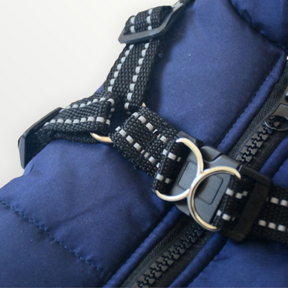 Close-up of the navy jacket's reflective black harness straps, adjustable buckles, metal D-rings and chunky zip on the quilted back. 6