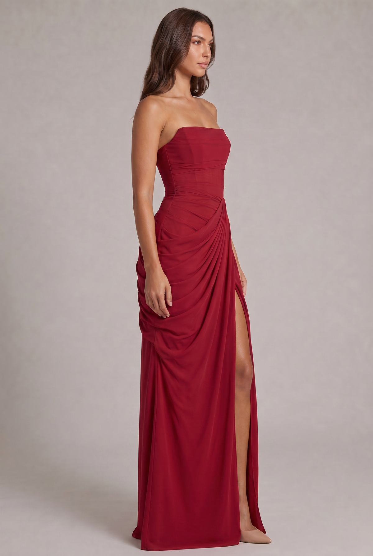 Side view of the red strapless dress showing the gathered drape and high slit 23