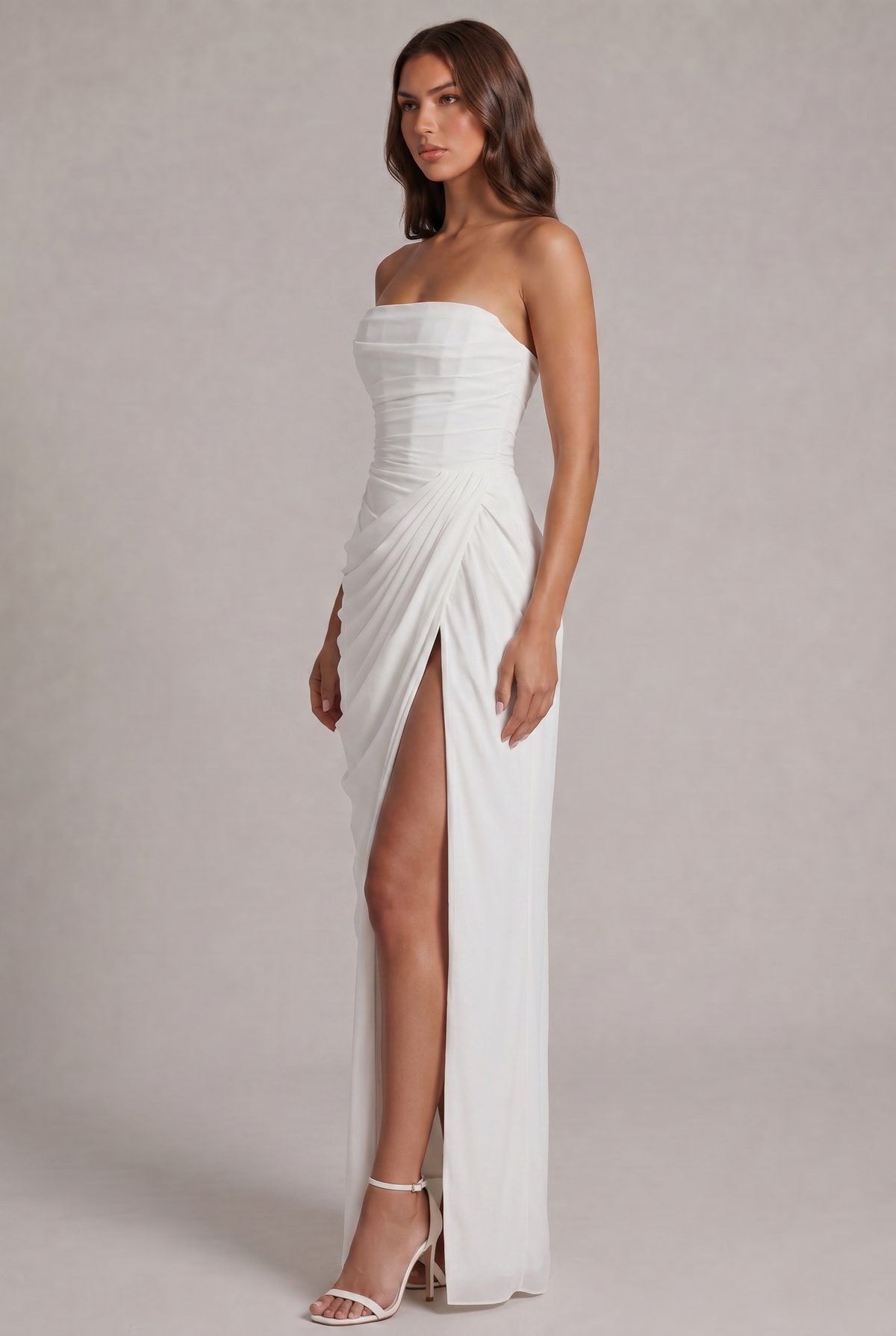 Angled side view of the white strapless dress with pleated wrap detail and slit 19