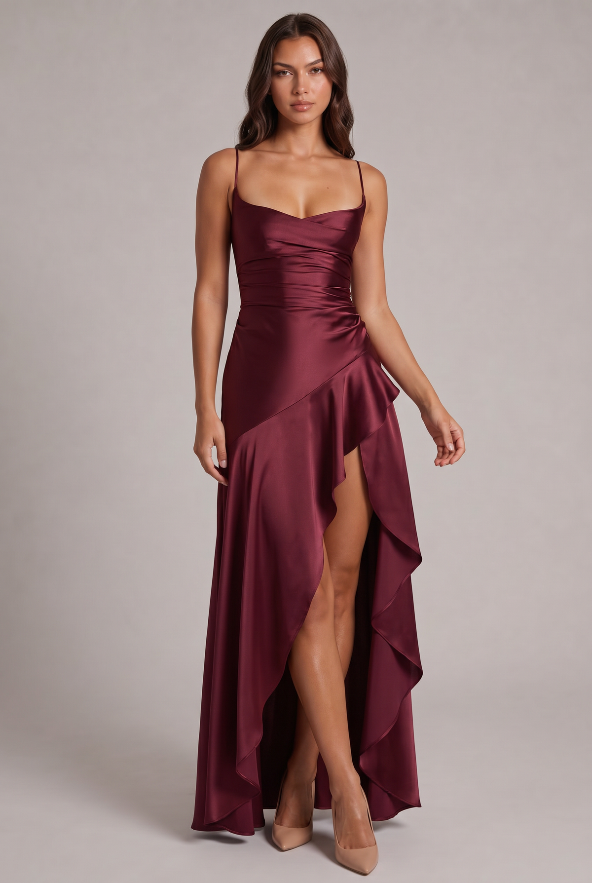 Model wearing the burgundy satin maxi dress, full-length front view with ruched waist, ruffled front slit and nude heels. 1
