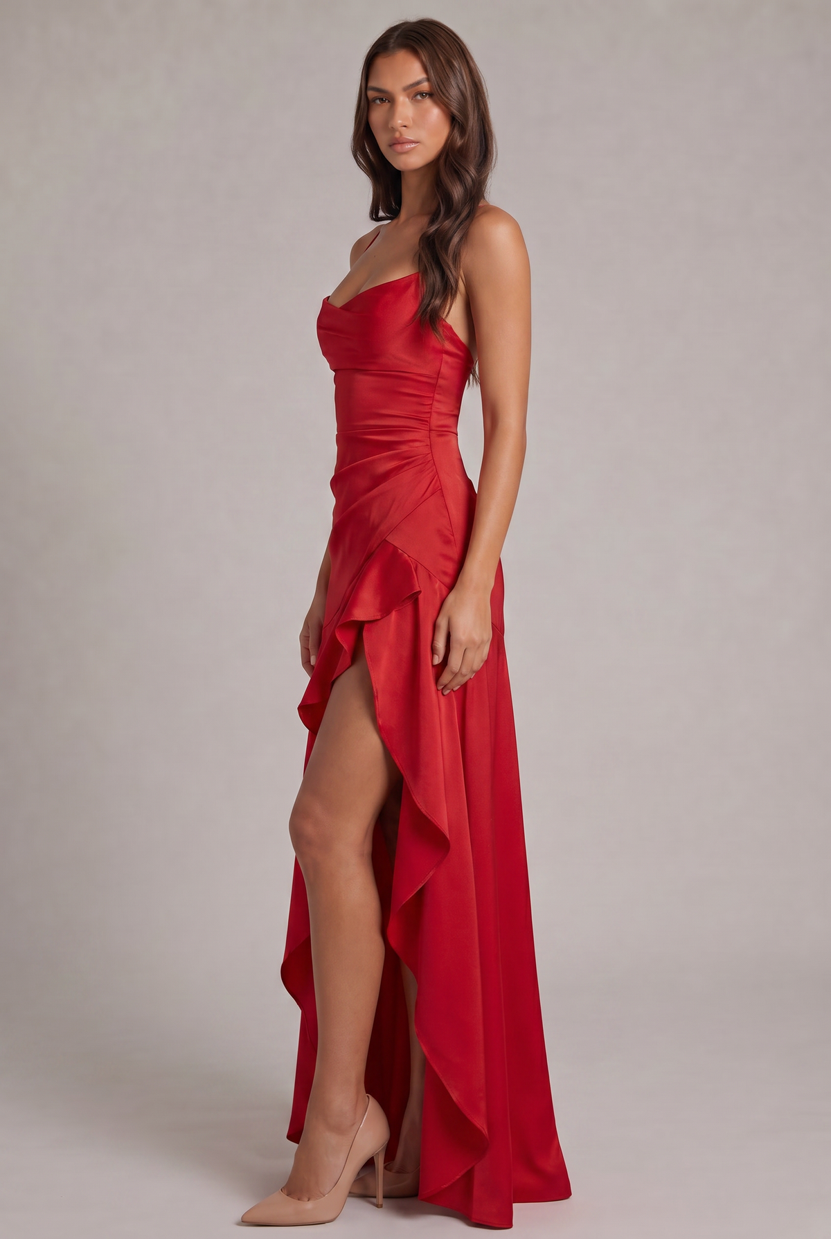 Side view of the red satin dress showing the ruched side, layered ruffle and slit over nude heels. 15