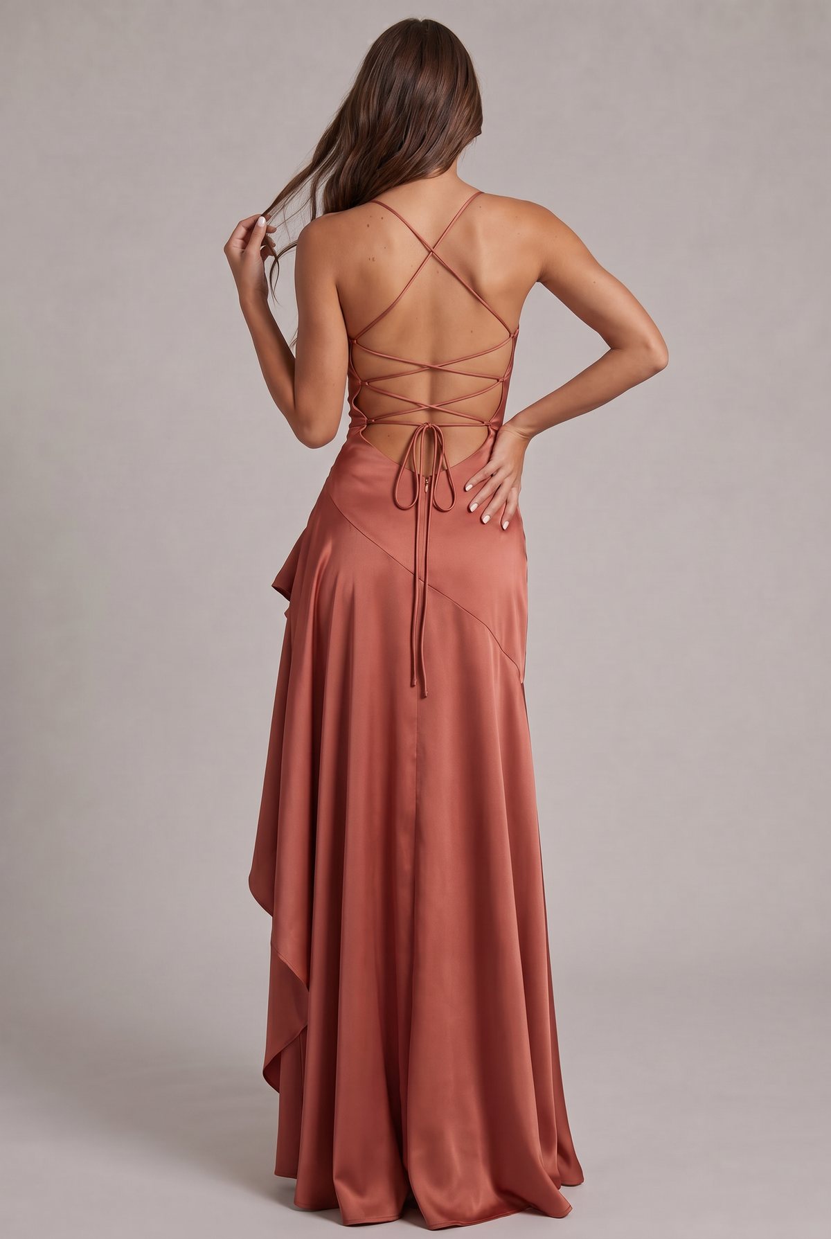 Back view of the terracotta satin dress, showing the crisscross lacing, bow ties and long ruffled skirt. 27