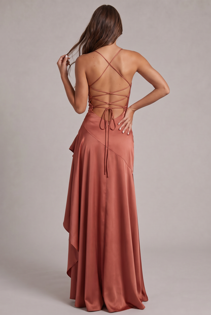 Back view of the terracotta satin dress, showing the crisscross lacing, bow ties and long ruffled skirt. 27
