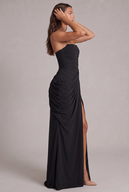 Side profile of the black strapless dress, hands in hair, showing draped hip and slit 27