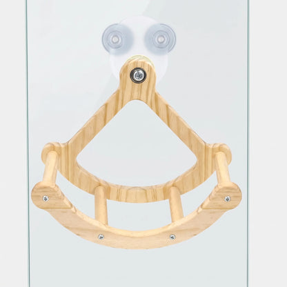 Wooden swing with a curved perch and two dowel rungs, fixed to a glass pane by two clear suction cups. 1