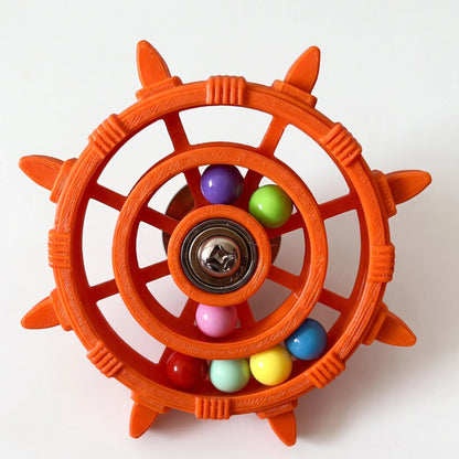 Orange version of the wheel toy with textured, ridged plastic, a metal bearing hub and multicoloured balls in the rings. 5
