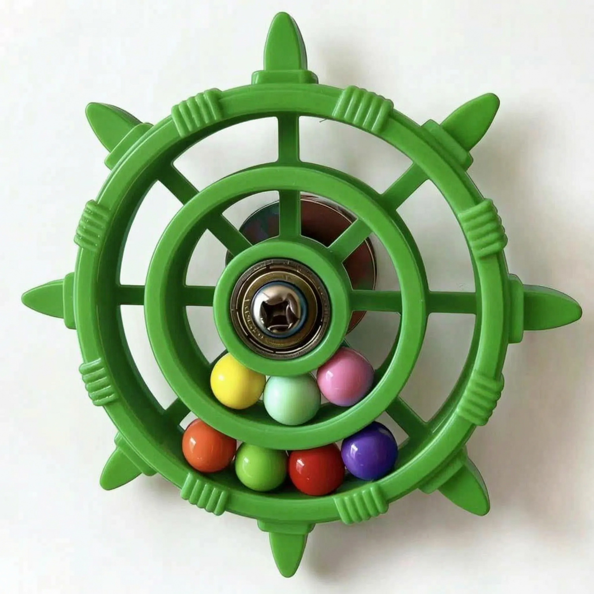 Green version of the wheel toy with eight pointed spokes, a metal bearing hub and seven coloured balls in the rim. 7