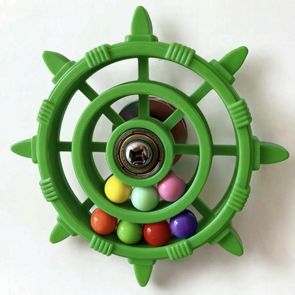 Green version of the wheel toy with eight pointed spokes, a metal bearing hub and seven coloured balls in the rim. 7