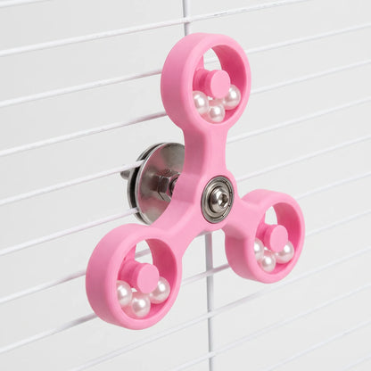 Angled view of the pink version of the spinner clamped to white cage bars, showing the steel washer and nut at the back. 5