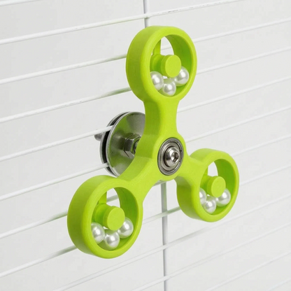 Angled view of the lime green version of the spinner clamped to white cage bars, with metal washer and nut visible behind. 6