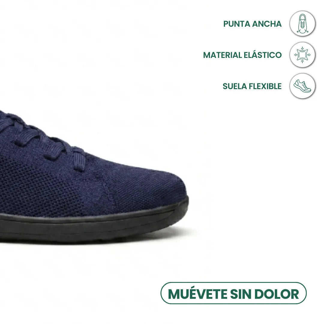 Close-up of the toe of a navy knit trainer with black sole, with icons for wide toe, stretchy material and flexible sole. 23