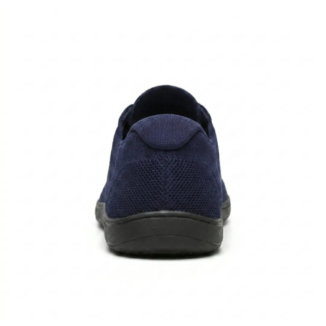 Rear view of a navy mesh trainer with black sole, showing the heel tab and knitted heel panel. 27