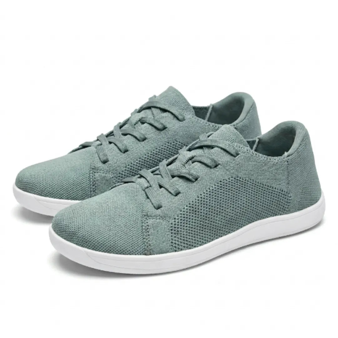 Pair of sage green mesh lace-up trainers with white soles, shown from the front three-quarter angle. 34