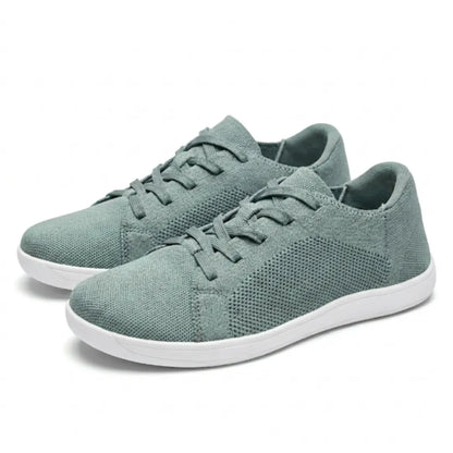 Pair of sage green mesh lace-up trainers with white soles, shown from the front three-quarter angle. 34