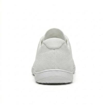 Rear view of a white knit trainer showing the heel tab, breathable mesh texture and flat white sole. 45