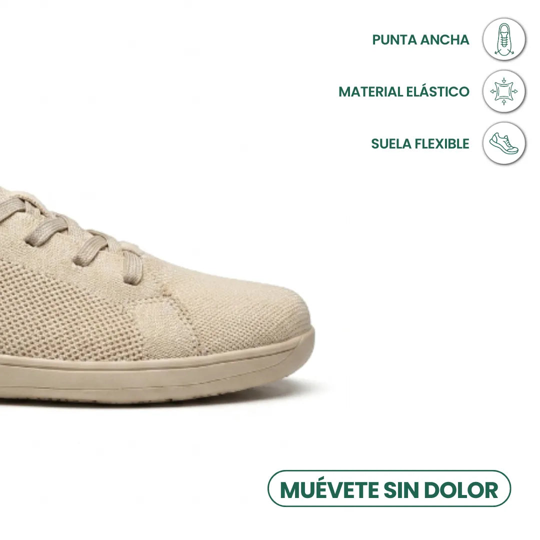 Close-up of the beige trainer's wide toe area with icons for roomy toe, stretchy material and flexible sole. 5