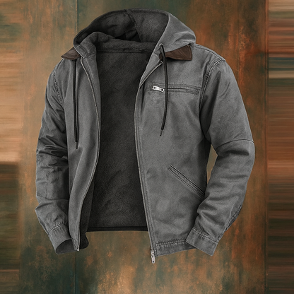 Grey version of the hooded jacket, open at the front with dark fleece lining and brown collar trim, on a rustic backdrop. 3