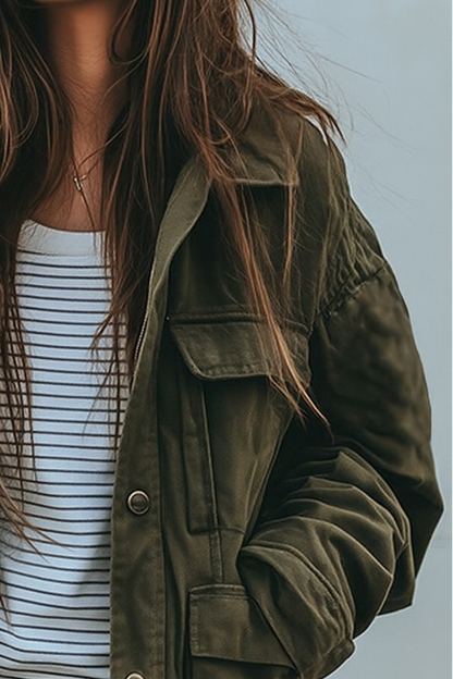 Close-up of the jacket's collar, flap chest pocket and gathered shoulder seam, worn over a striped top. 2