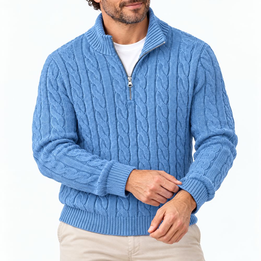 Close-up of a model wearing the blue cable knit half-zip jumper over a white tee, adjusting a ribbed cuff. 1