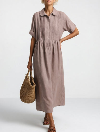 Model in the muted mauve-taupe dress with a hand on hip, showing the rounded collar, pintucks and relaxed fit. 8