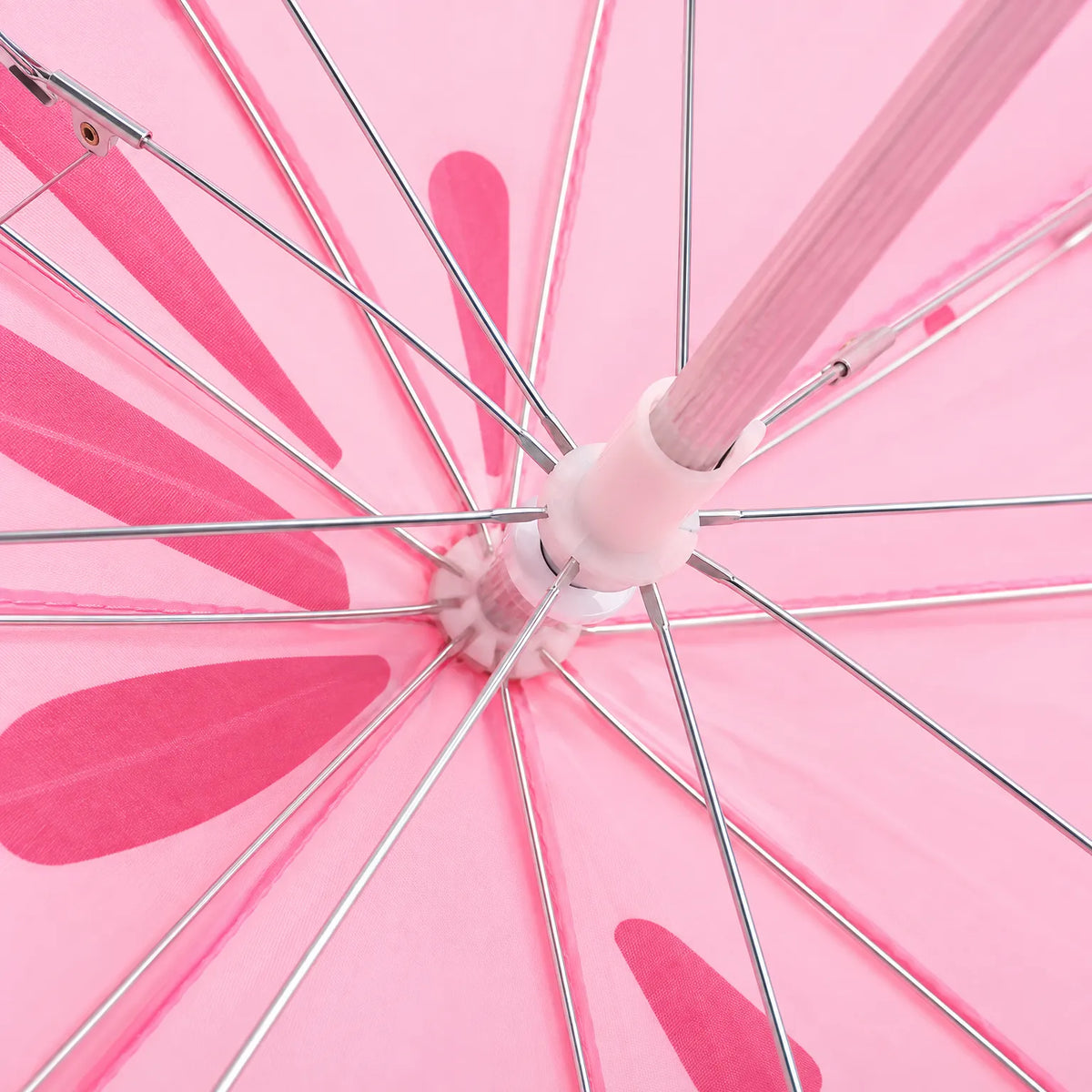 Close-up of the underside of the open pink umbrella, showing the metal ribs, central hub and shaft. 3