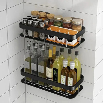 Black shelf on marble-effect tiles holding amber bottles, a reed diffuser and a pump dispenser 2