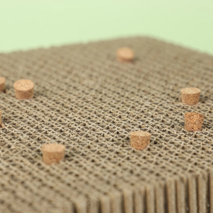 Close-up of the layered cardboard surface showing the honeycomb texture and several cork stoppers set into it, against a pale green background. 4