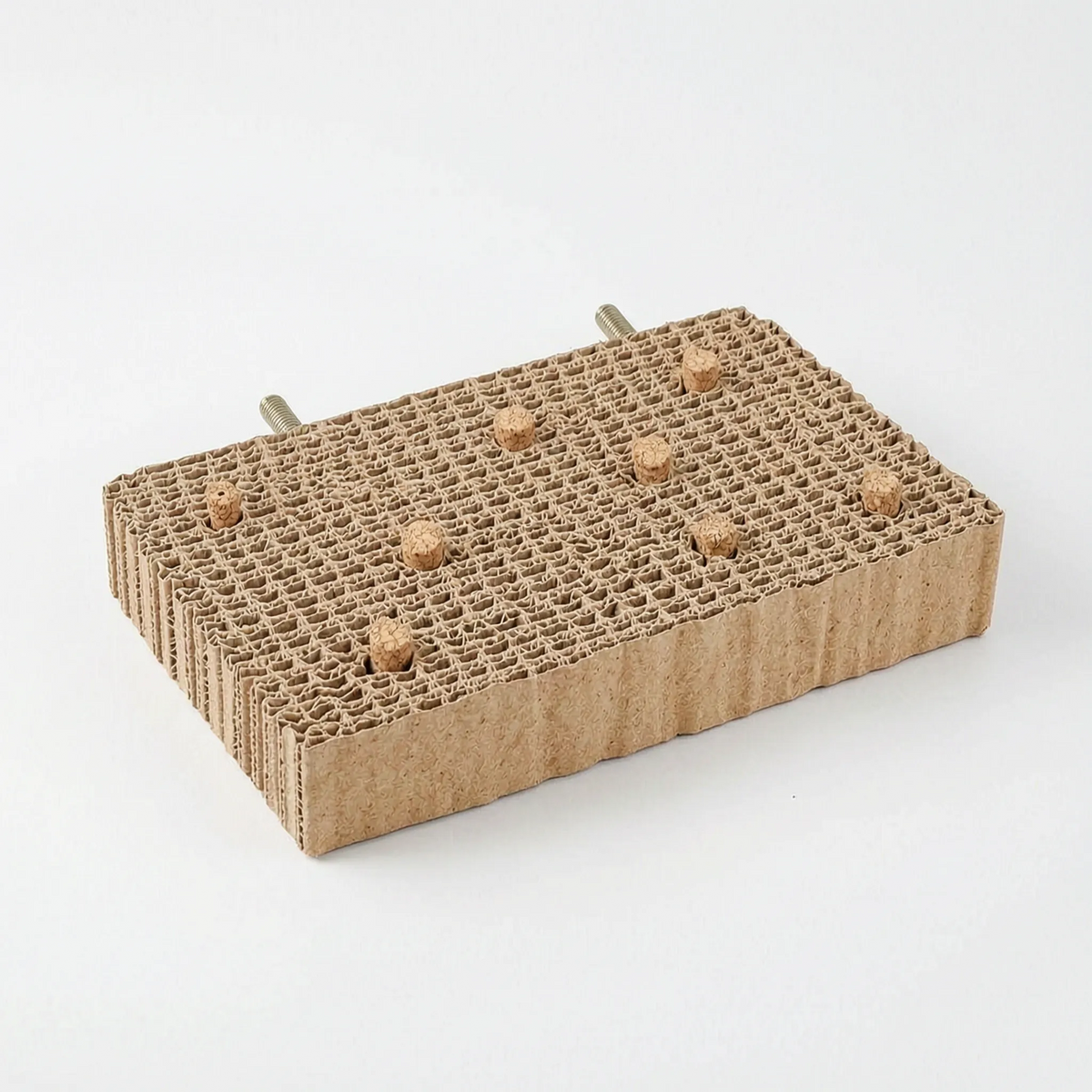 Rectangular cardboard platform with seven cork stoppers in its top and two threaded bolts at the back, on white. 8