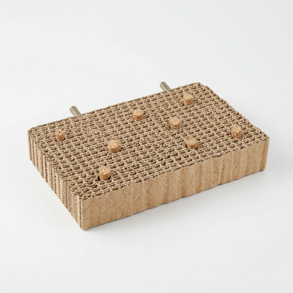 Rectangular cardboard platform with seven cork stoppers in its top and two threaded bolts at the back, on white. 8