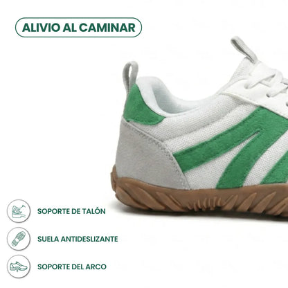 Close-up of the heel and side of the white and green shoe with grey suede heel and gum sole, with feature icons. 31