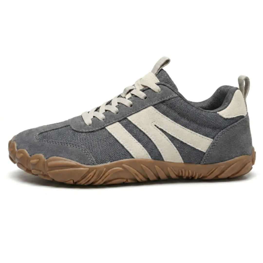 Side view of the grey mesh and suede barefoot shoe with cream stripes, cream laces and a flexible tan rubber sole. 1