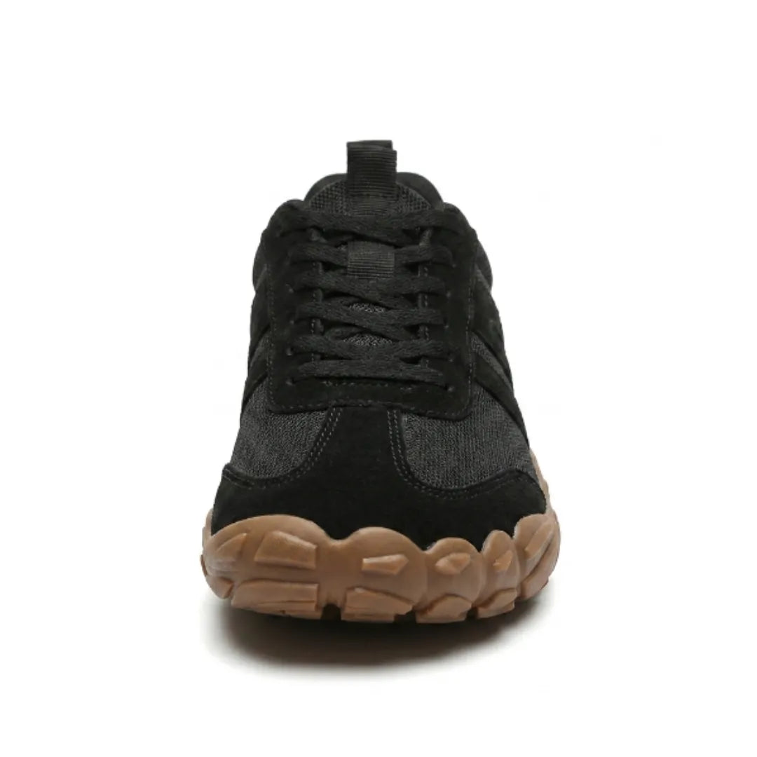 Front view of a black lace-up shoe showing the broad rounded toe and chunky tan gum sole. 26