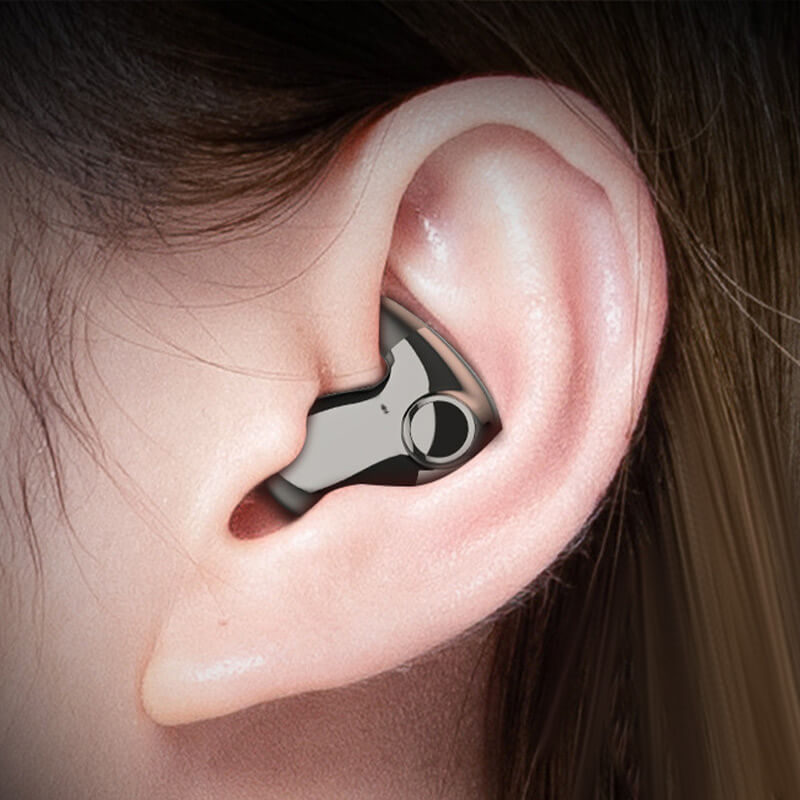 Close-up of a dark metallic-finish earbud sitting low-profile inside a woman's ear 1