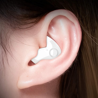 Close-up of a white earbud with a round button ring, worn in an ear 3