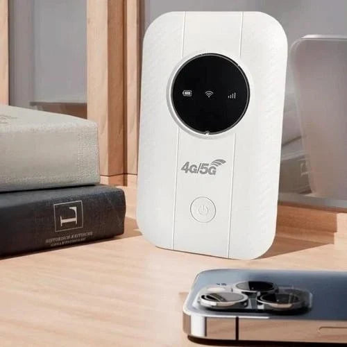 White hotspot standing upright on a wooden shelf between books and a smartphone with a triple camera 3