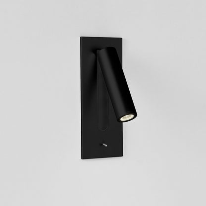 White wall light with black recess and lit tube angled out to the right, toggle switch below 12