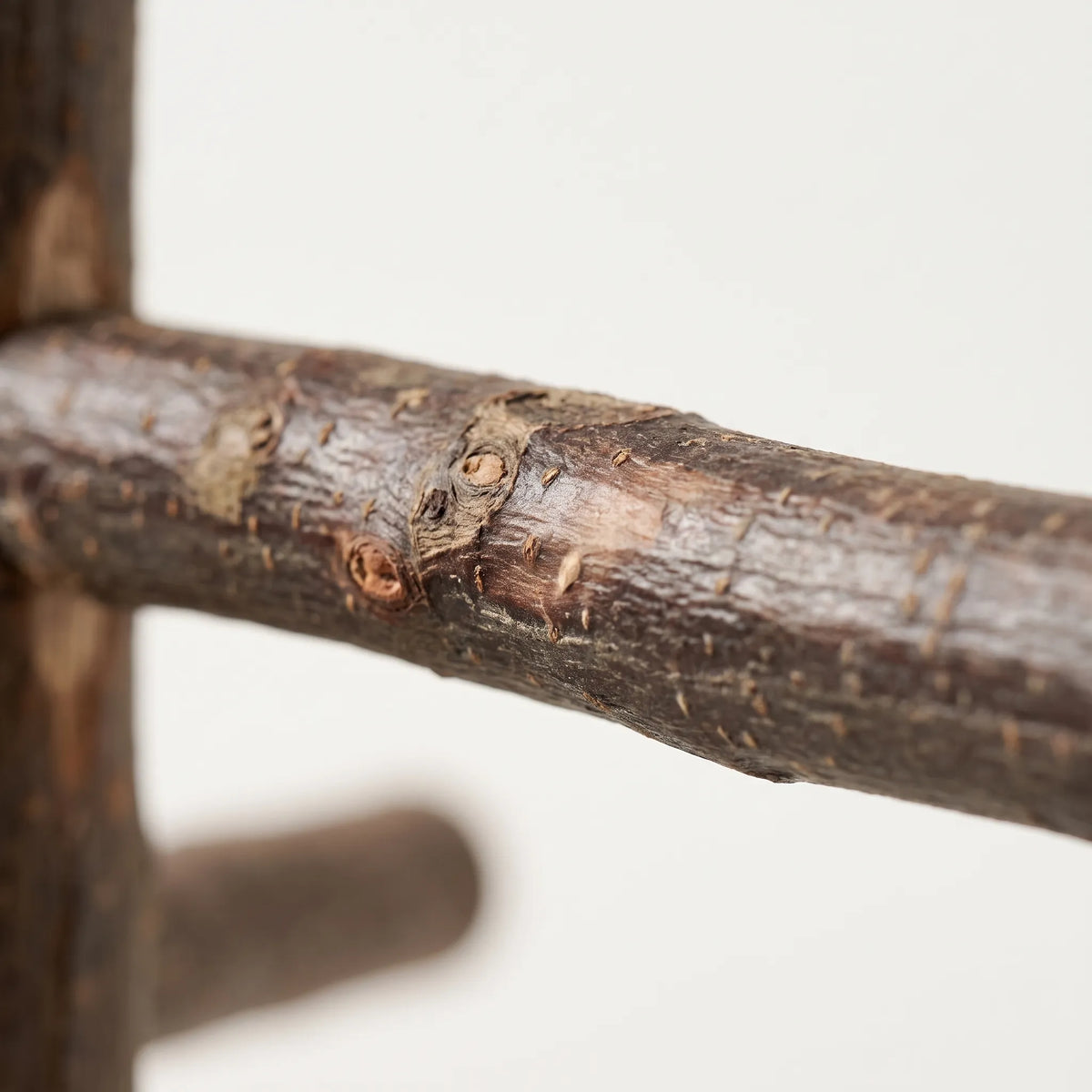 Close-up of one rough side branch showing the knots and textured bark of the natural wood. 3