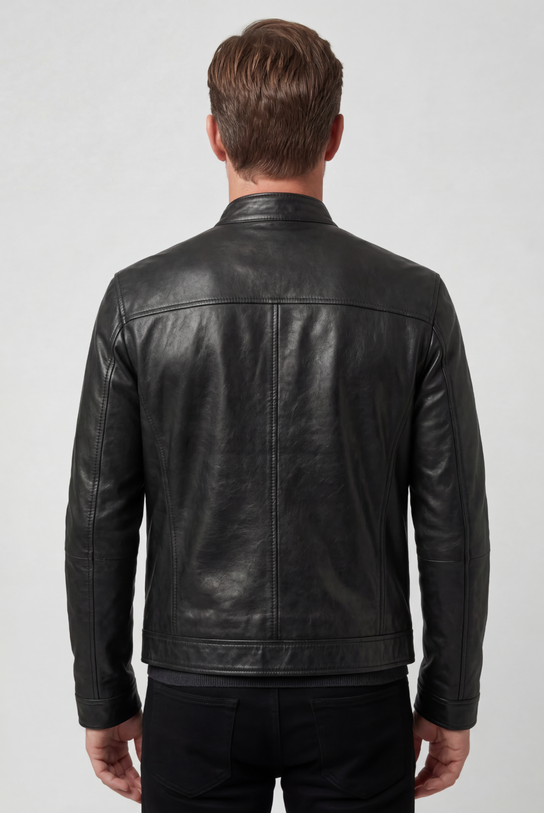 Back view of the black jacket on a model, showing the plain panelled back and stitched hem band 2
