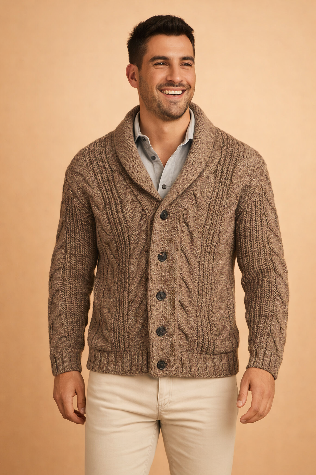 Close front view of the brown marl cardigan on a smiling model, showing the chunky cables, ribbed hem, front buttons and patch pockets. 3