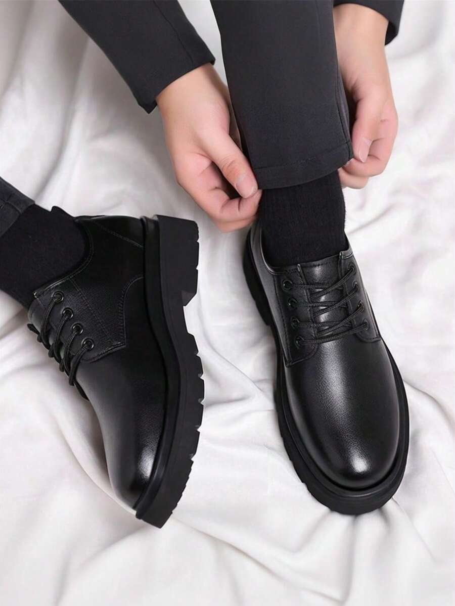 Wearer adjusting trouser hem above one shoe, with the other shoe beside it, from above 3
