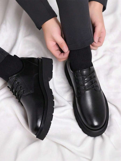 Wearer adjusting trouser hem above one shoe, with the other shoe beside it, from above 3