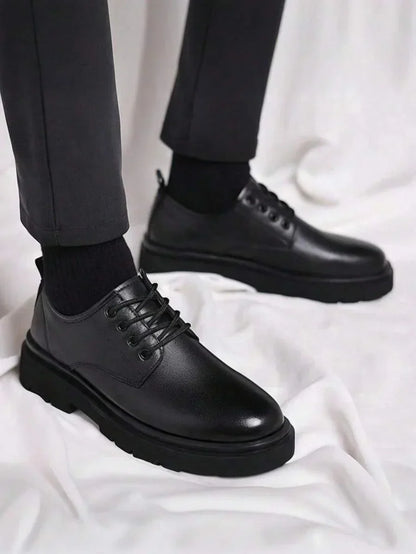 Pair of lace-up derby shoes worn with dark trousers and black socks on white fabric 1